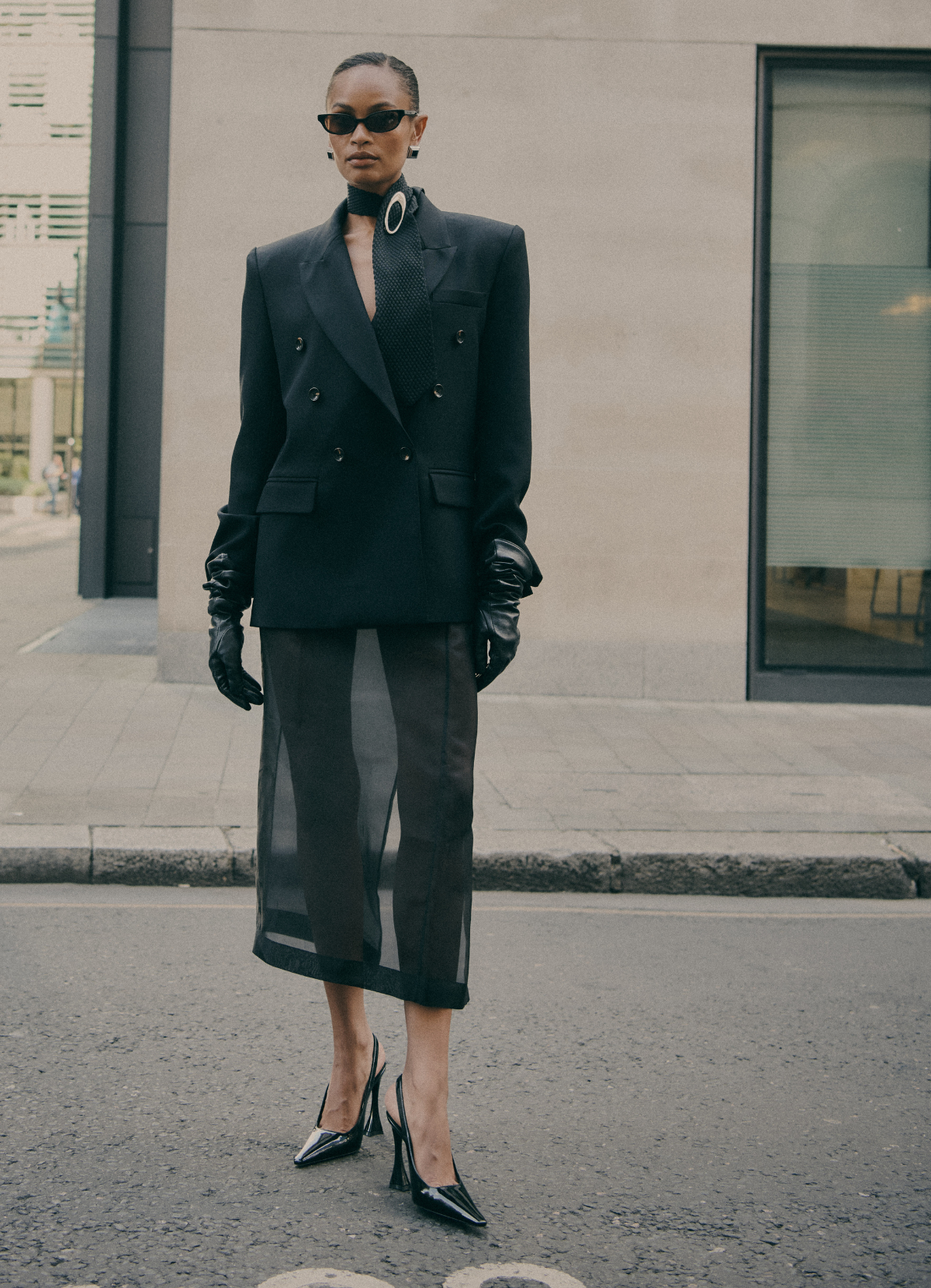 Tailored black wool double-breasted blazer worn by model, by de Savary London.
