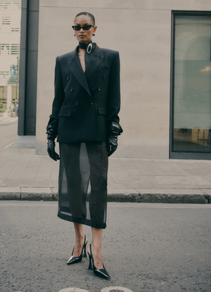 Tailored black wool double-breasted blazer worn by model, by de Savary London.