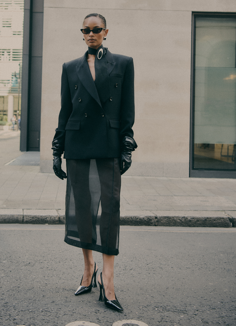 Tailored black wool double-breasted blazer worn by model, by de Savary London.