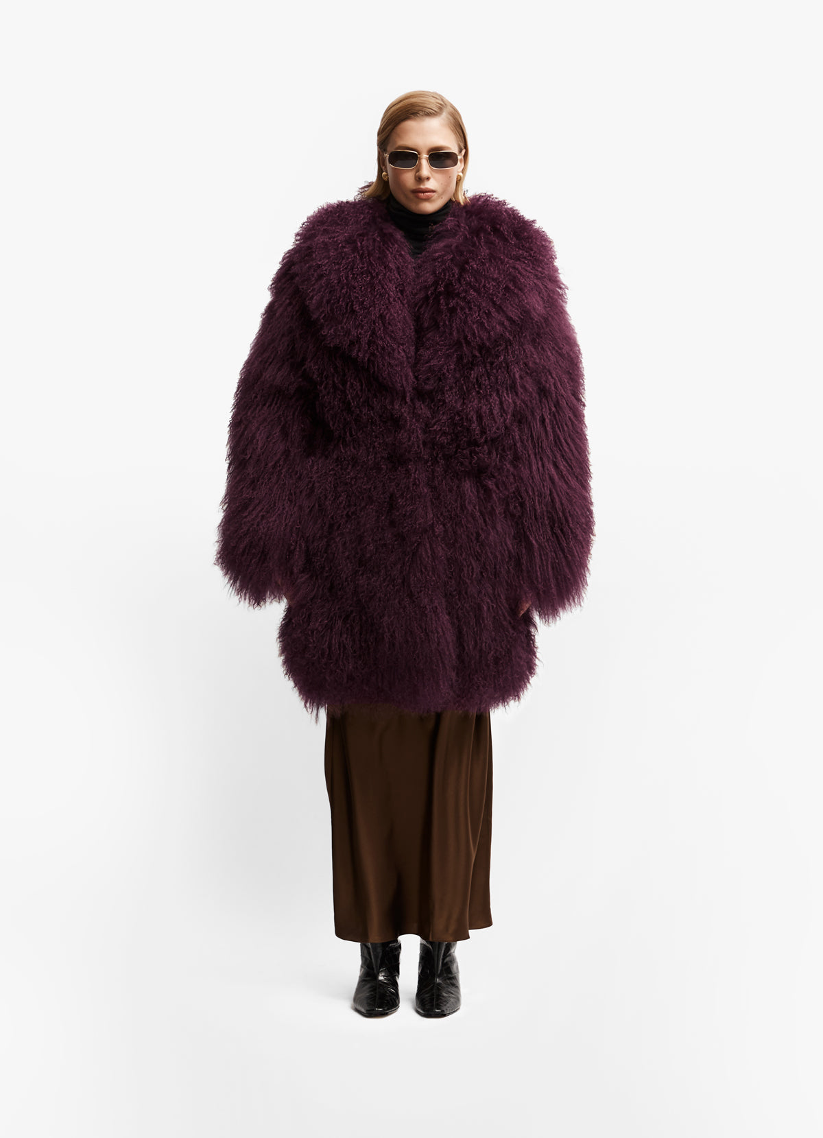 Model front facing wearing long length burgundy mongolian wool coat with collar.